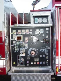 Pump panel close-up showing gauges, valves, and discharge controls
