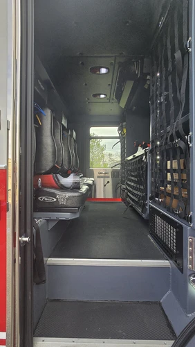 Rear crew area interior view showing bench seats, SCBA mounts, and side storage racks