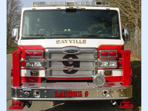 Head-on front view showing the grille, bumper, deployed front outriggers, and warning lights.