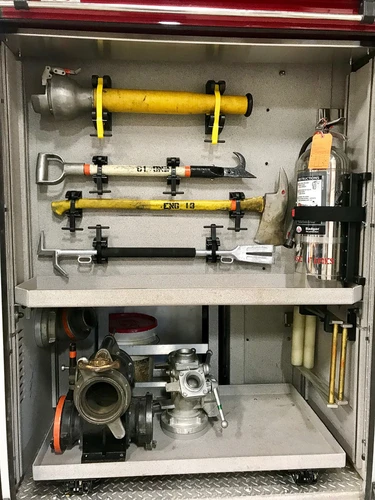Open side compartment showing mounted hand tools and hose fittings