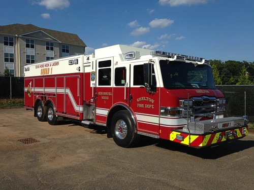 Heavy rescue pumper front-left exterior view showing tandem rear axles and long body