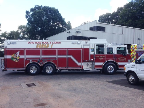 Driver-side full profile showing tandem rear axles and rescue compartments