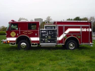 Driver-side profile view showing exposed pump panel, hose connections, and side compartments