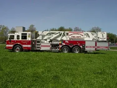 Full right-side profile showing the mid-mount ladder assembly, body compartments, and wheel layout.