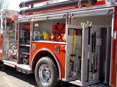 Driver-side mid-body view with open compartments showing mounted hand tools and storage