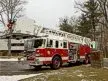Wide front-left thumbnail view of the tower ladder with stowed aerial and bucket.