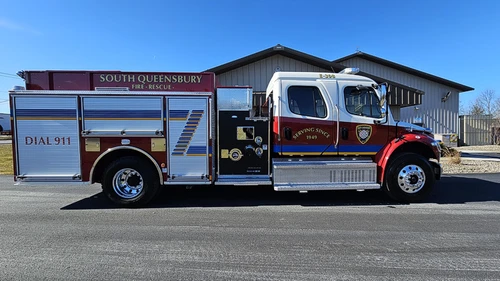 Driver-side full profile showing pumper body and side compartments