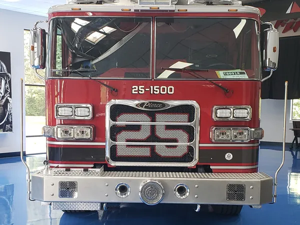 Front exterior view indoors showing grille, bumper, and warning lights