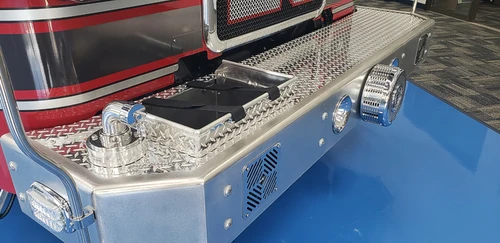 Front bumper close-up showing intake ports, lights, and treadplate step