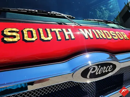 Front grille close-up showing raised department script and Pierce badge