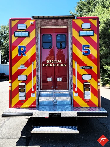 Rear view showing red-and-yellow chevrons and closed rear doors