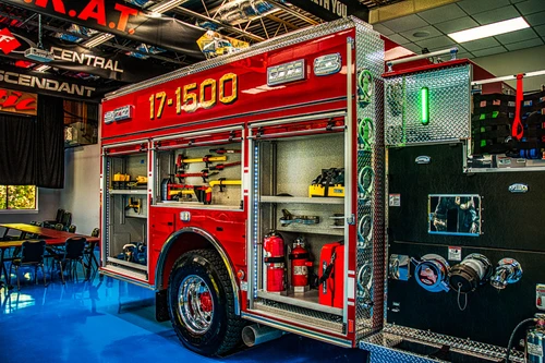Driver-side open compartments showing extinguishers, tools, and pump-side storage