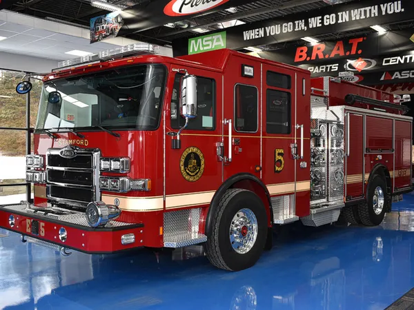 Pumper front-left exterior view showing grille, bumper, and enclosed cab