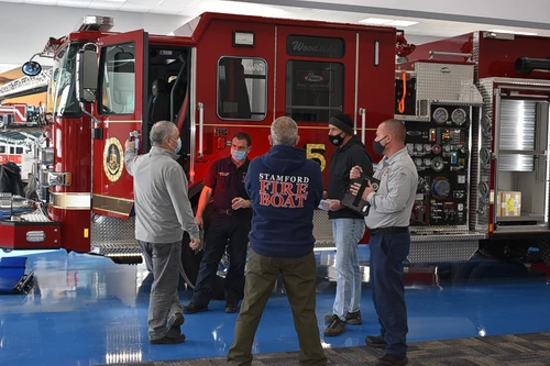 Station-floor scene view showing pumper with people standing near cab