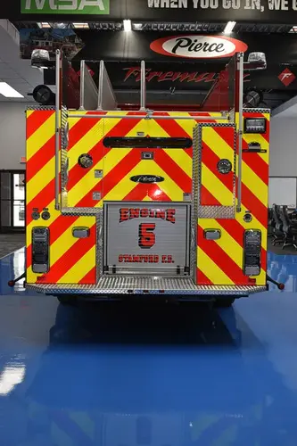 Rear view showing red-and-yellow chevrons and tailboard compartment area