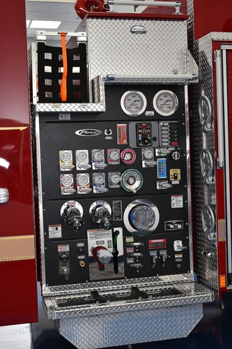 Pump panel close-up showing gauges, valves, and labeled control knobs