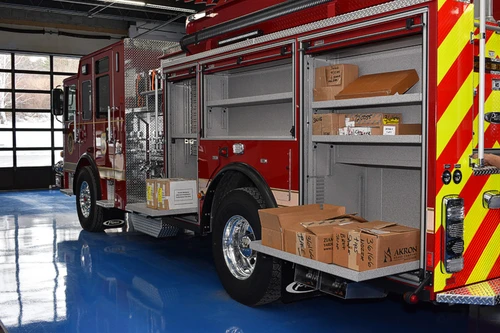 Officer-side profile with open rear compartment showing wood cribbing blocks