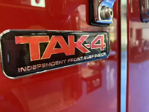 Body badge close-up showing TAK-4 suspension emblem