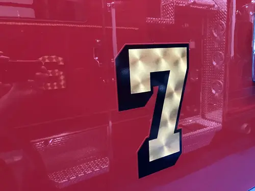 Body panel close-up showing large unit number decal on red paint