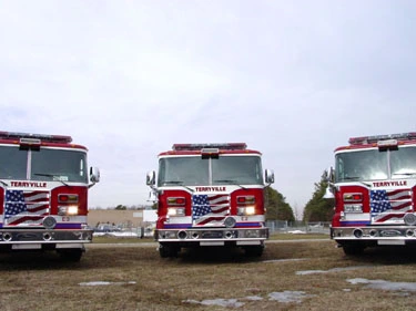 Front lineup view of multiple pumpers showing grilles, bumpers, and light bars