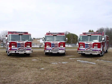 Wide front lineup view showing multiple pumper cabs and bumpers