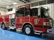 Wide front left indoor view of the parked pumper showing cab, bumper, and side body.