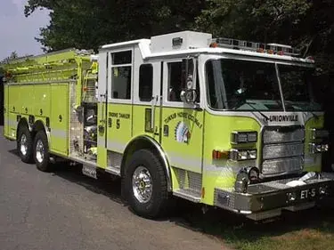 Tanker-pumper front-left exterior view showing enclosed cab and long body