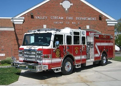 Pumper front-left exterior view parked at station showing enclosed cab