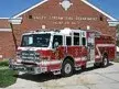 Pumper front-left exterior view parked at station showing enclosed cab