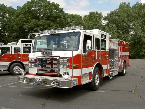 Front-left exterior view showing cab, bumper, and side body