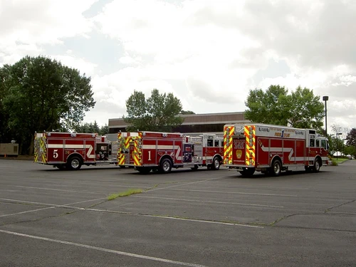 Wide rear-side lineup view showing multiple apparatus in parking lot