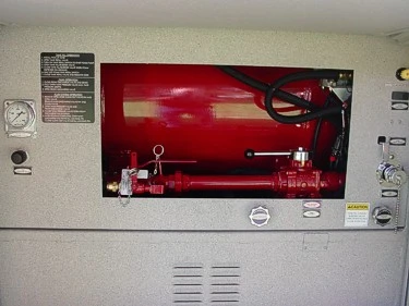 Open side-compartment close-up showing mounted red tank, plumbing components, and control fittings.