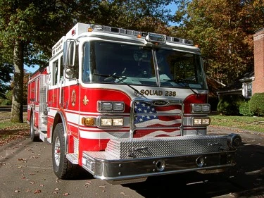 Front-left close view highlighting the grille, bumper, windshield, and warning lights.