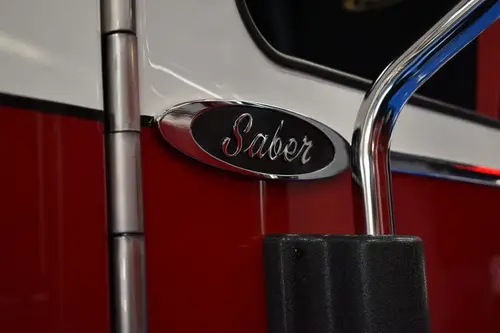 Body badge close-up showing Saber emblem on red panel
