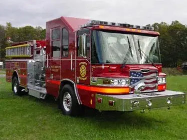 Front-left exterior view of pumper showing chrome bumper and American-flag grille