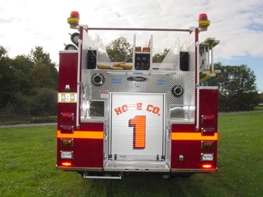 Rear view showing tailboard, upper hosebed access, and rear panel marked 1