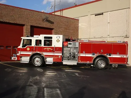 Driver-side full profile showing pumper body and side compartments
