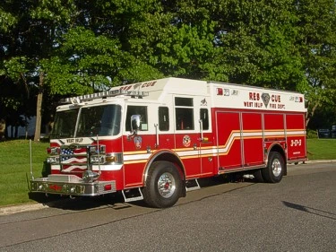 Front-left exterior view of a rescue truck with enclosed cab, long side body, and wheel/tire area.