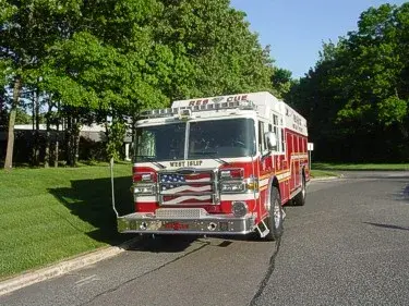 Front view angled left showing grille, bumper, warning lights, and windshield.
