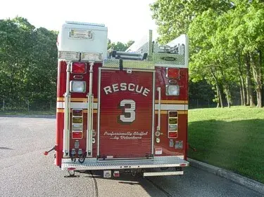 Straight rear view showing rear warning lights, rear access door, and upper rear platform area.
