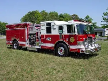 Front-left exterior view on grass showing enclosed cab and side body
