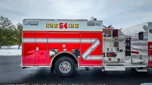 Driver-side full profile showing pumper body and side compartments