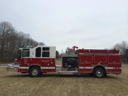 Officer-side profile view showing exposed pump panel controls and side compartment doors.