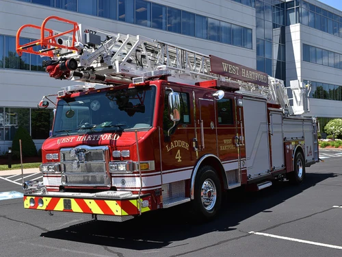 Tower ladder truck front-left exterior view showing cab and ladder bed