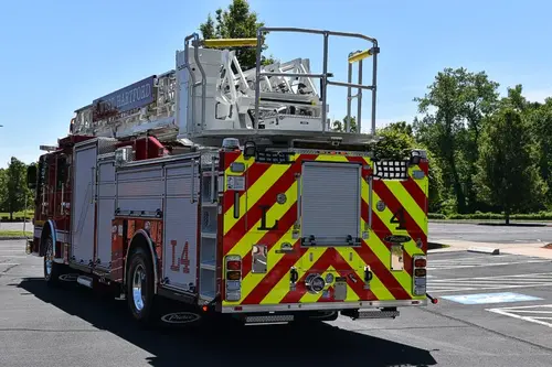 Rear-right exterior view showing chevrons and bucket at ladder tip