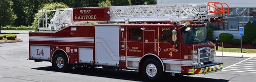 Tower ladder truck side profile view parked in lot with closed compartments