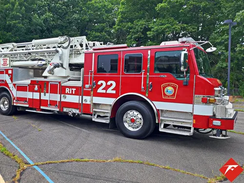 Tower ladder truck driver-side profile view showing aerial ladder and side body