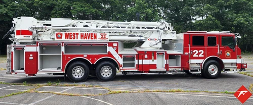 Driver-side full profile showing tower ladder body and tandem wheels
