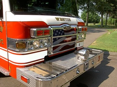 Front bumper close-up showing grille, treadplate step, and warning lights
