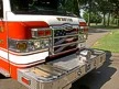 Front bumper close-up showing grille, treadplate step, and warning lights